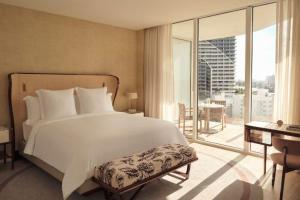 a bedroom with a large white bed and a balcony at Four Seasons Hotel and Residences Fort Lauderdale in Fort Lauderdale