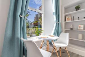 a dining room with a table and chairs and a window at Beautiful Ground Floor Apartment in Perth
