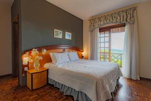 a bedroom with a large bed and a window at Spaço Vale do Jordão Guarapuava in Guarapuava