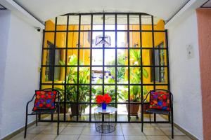 Habitación con ventana con mesa y 2 sillas en Hotel Hacienda Cancun en Cancún