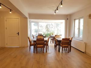 a dining room with tables and chairs and a large window at Seron Mountain House in Geyikbayırı