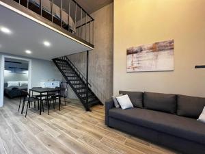 a living room with a couch and a table and a staircase at VLC Apart in Valencia