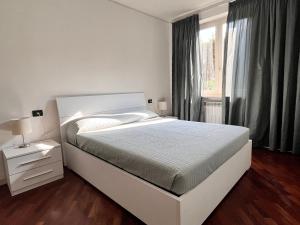 ein weißes Schlafzimmer mit einem Bett und einem Fenster in der Unterkunft Appartamento tranquillo BARCODE HOUSE in Erbusco