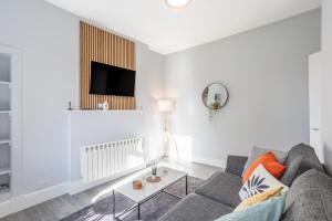 ein Wohnzimmer mit einem Sofa und einem TV in der Unterkunft Beautiful Ground Floor Apartment in Perth
