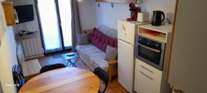 Habitación pequeña con mesa y sofá en studio-cabine 4 pers, wifi et garage. en Ax-les-Thermes