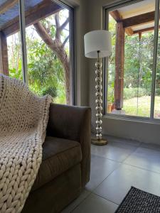 un soggiorno con divano, lampada e finestre di Modern House for Families A/C a Turrialba