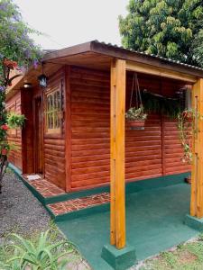 eine Holzhütte mit einer Veranda und einer Tür in der Unterkunft Cabaña Joshua in Puerto Iguazú