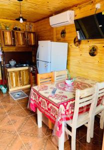 伊瓜蘇港的住宿－Cabaña Joshua，厨房配有桌椅和冰箱。