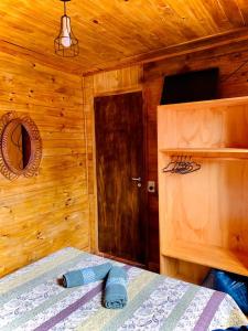 1 dormitorio con 1 cama y pared de madera en Cabaña Joshua en Puerto Iguazú