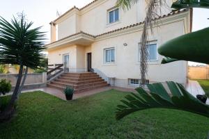 a large house with stairs and a grass yard at Apartoyou - Chalet & Pool in El Puerto de Santa María