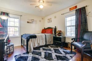 1 dormitorio con 1 cama, 1 silla y ventanas en Cozy Indiana Home with Deck, Charcoal Grill and Yard!, en Marion