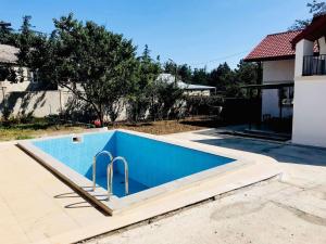 einem blauen Pool mit Rampe im Hof in der Unterkunft Vila Mtatsminda in Okrokana