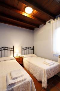 1 dormitorio con 2 camas y ventana en Casa Rural Puerta del Sol II de 2 habitaciones en Candelario