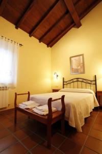 Un dormitorio con una cama y una mesa con toallas. en Casa Rural Puerta del Sol II de 2 habitaciones, en Candelario