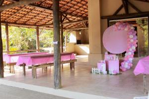 een roze pingpongtafel in een paviljoen met ballonnen bij Sítio Monte Sião in Major