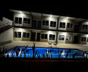 a building with a swimming pool at night at Apartamentos Sin fronteras in Leticia