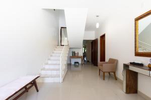a white hallway with stairs and a mirror at HOSTEL DIKASA in Cuiabá