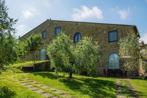 uma casa de pedra com uma árvore em frente em Borgo Collelungo apartments in Montaione em La Collina