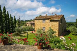uma casa de pedra num jardim com flores em Borgo Collelungo apartments in Montaione em La Collina