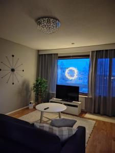 a living room with a table in front of a tv at City Apartment Tieva in Rovaniemi
