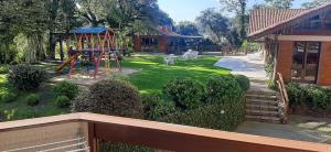 een achtertuin met een speeltuin met een glijbaan bij POUSADA DO SERRANO 318 in Gramado