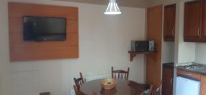 een keuken met een tafel en een televisie aan de muur bij POUSADA DO SERRANO 318 in Gramado +6 foto's