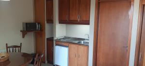 een kleine keuken met een wastafel en een tafel bij POUSADA DO SERRANO 318 in Gramado