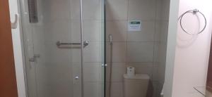 een douche in een badkamer met een toilet en een glazen deur bij POUSADA DO SERRANO 318 in Gramado