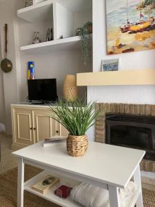 uma sala de estar com uma mesa com uma planta em El Portil, Punta Umbría. A 300m playa. Piscina em El Portil