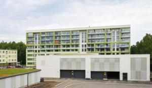 a large building with a parking lot in front of it at New built One bedroom Apartment nearby Train station in Vantaa