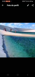 uma imagem de uma praia com pessoas na areia e na água em Camp Testar Branca Circuito Lagoa bonita em Barreirinhas