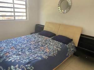 a bedroom with a bed with a blue blanket and a mirror at Casa Linda - Habitacion Puerto Morelos-Cancun-Playa Del Carmen in Puerto Morelos