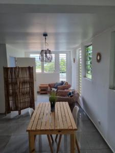 a living room with a table and a couch at Logement de roots evasions in Petit-Bourg