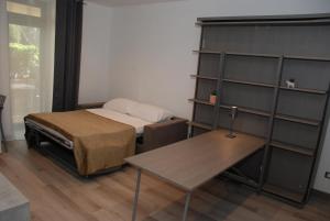 Zimmer mit einem Bett, einem Tisch und Regalen in der Unterkunft Giardino del Mare in Bordighera