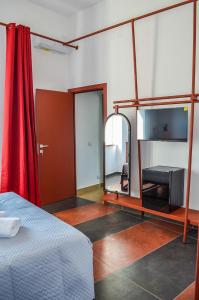 a room with a bed and a mirror and a red curtain at Scavi 32 in Ercolano