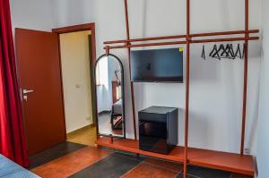 ein Zimmer mit einem Spiegel und einem Fernseher in einem Zimmer in der Unterkunft Scavi 32 in Ercolano