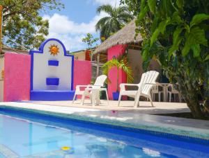 un complejo con sillas y piscina en Hotel Hacienda Cancun, en Cancún