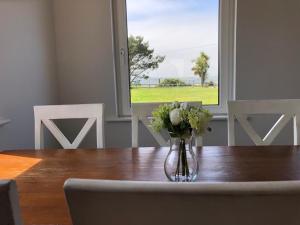 a vase of flowers sitting on a wooden table at Harbour View Cottage, Rochespoint, Cork Harbour in Midleton