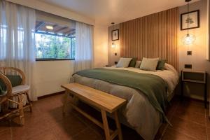 a bedroom with a bed and a table and a window at Cabañas Rio Soñado in Valle Grande +145 photos