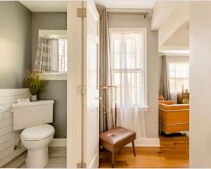 a bathroom with a white toilet and a window at Pittsford Garden Retreat in Pittsford