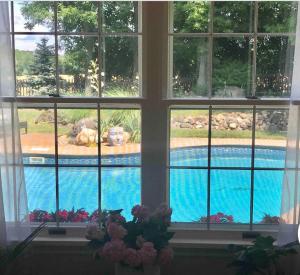 a view of a swimming pool through a window at Pittsford Garden Retreat in Pittsford