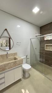 Un baño con inodoro y ducha de cristal. en Casa Sossego Trancoso, en Trancoso 21 fotos más