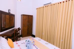 una camera con un letto e un tavolo con una scatola di Yala Wild Hut - Backpackers Lodge a Tissamaharama