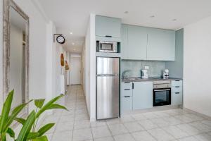 een keuken met witte kasten en een roestvrijstalen koelkast bij Apartment Viña del Mar in Playa Fañabe