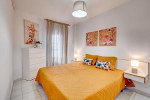 een slaapkamer met een geel bed met 2 kussens bij Apartment Viña del Mar in Playa Fañabe +8 foto's
