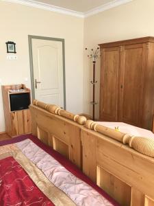 a bedroom with a wooden bed and a tv at Falubíró Vendégháza in Bekölce