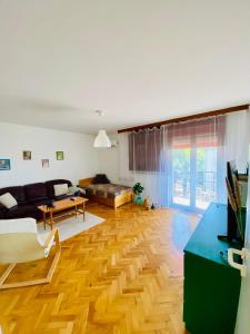 a living room with a wooden floor and a couch at Entire Apartment in the City in Dunaújváros
