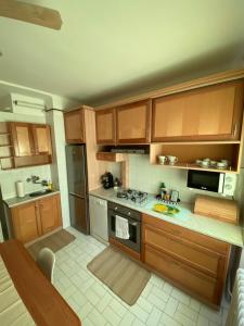 uma cozinha com armários de madeira e um forno com placa de fogão em Entire Apartment in the City em Dunaújváros