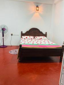 a bed sitting in a room with a fan at Robert Inn Dambulla in Dambulla