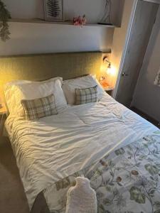 a large bed with white sheets and pillows at Luxury caravan in Morecambe